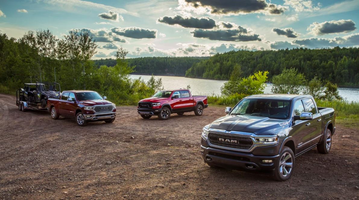 three 2023 RAM 1500 EcoDiesel trucks parked by a lake