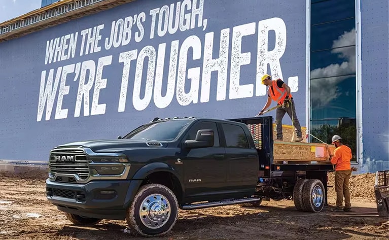 construction workers in the bed of a Ram truck