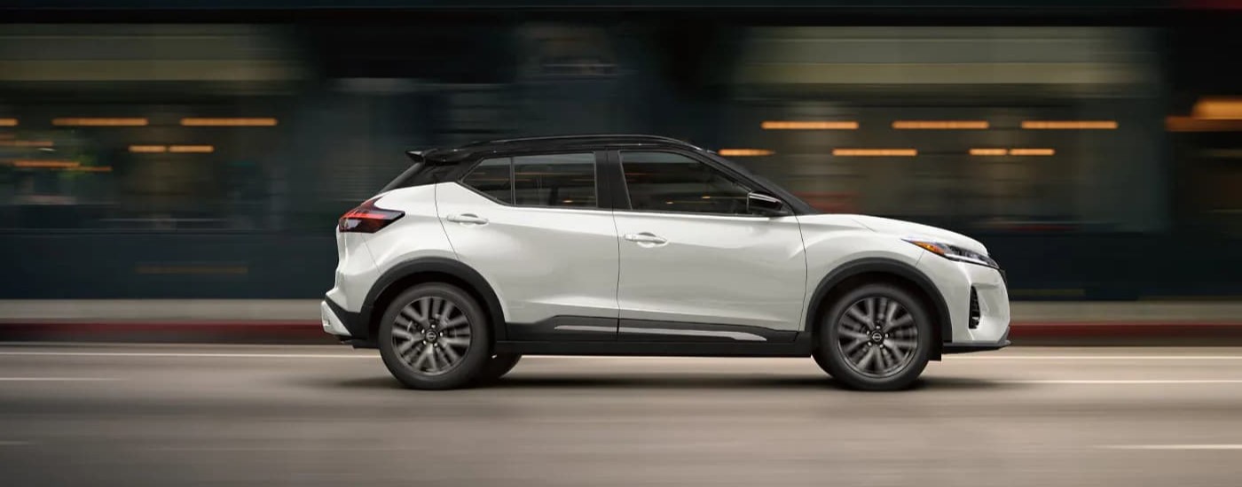 White 2024 Nissan Kicks driving in a city