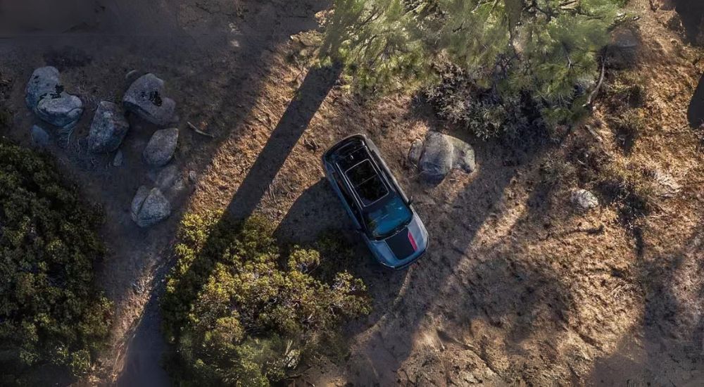 A grey 2024 Jeep Compass Trailhawk is shown off-road after visiting a Jeep dealer near Dekalb.