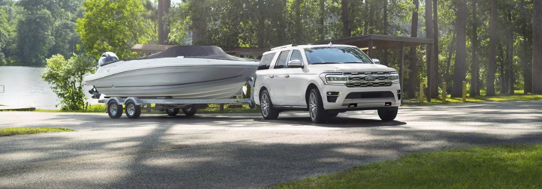 White 2024 Ford Expedition Towing a Boat by Water