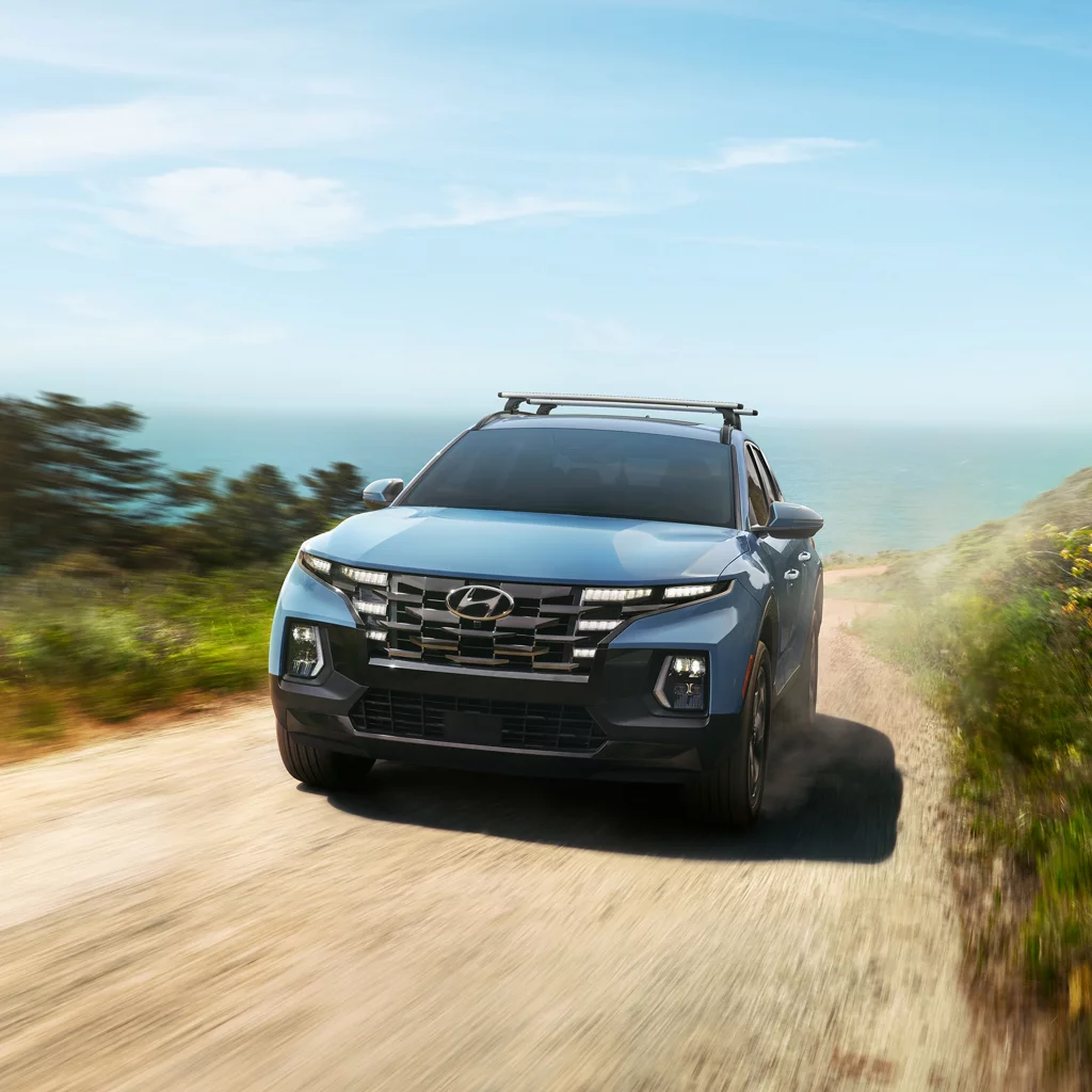 A 2024 Hyundai Santa Cruz driving on a dirt road.