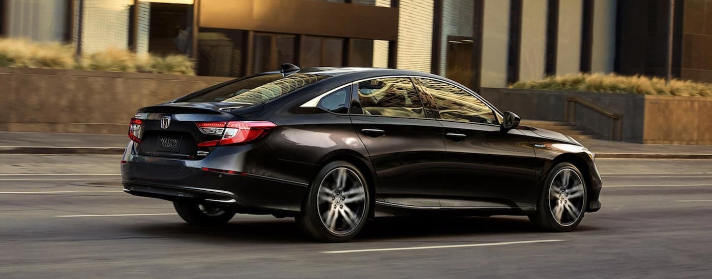 Black 2022 Honda Accord Hybrid Touring driving on a city street