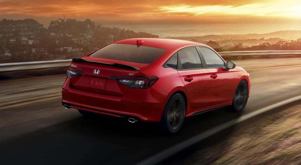 A red 2024 Honda Civic Si is shown from the rear at an angle.