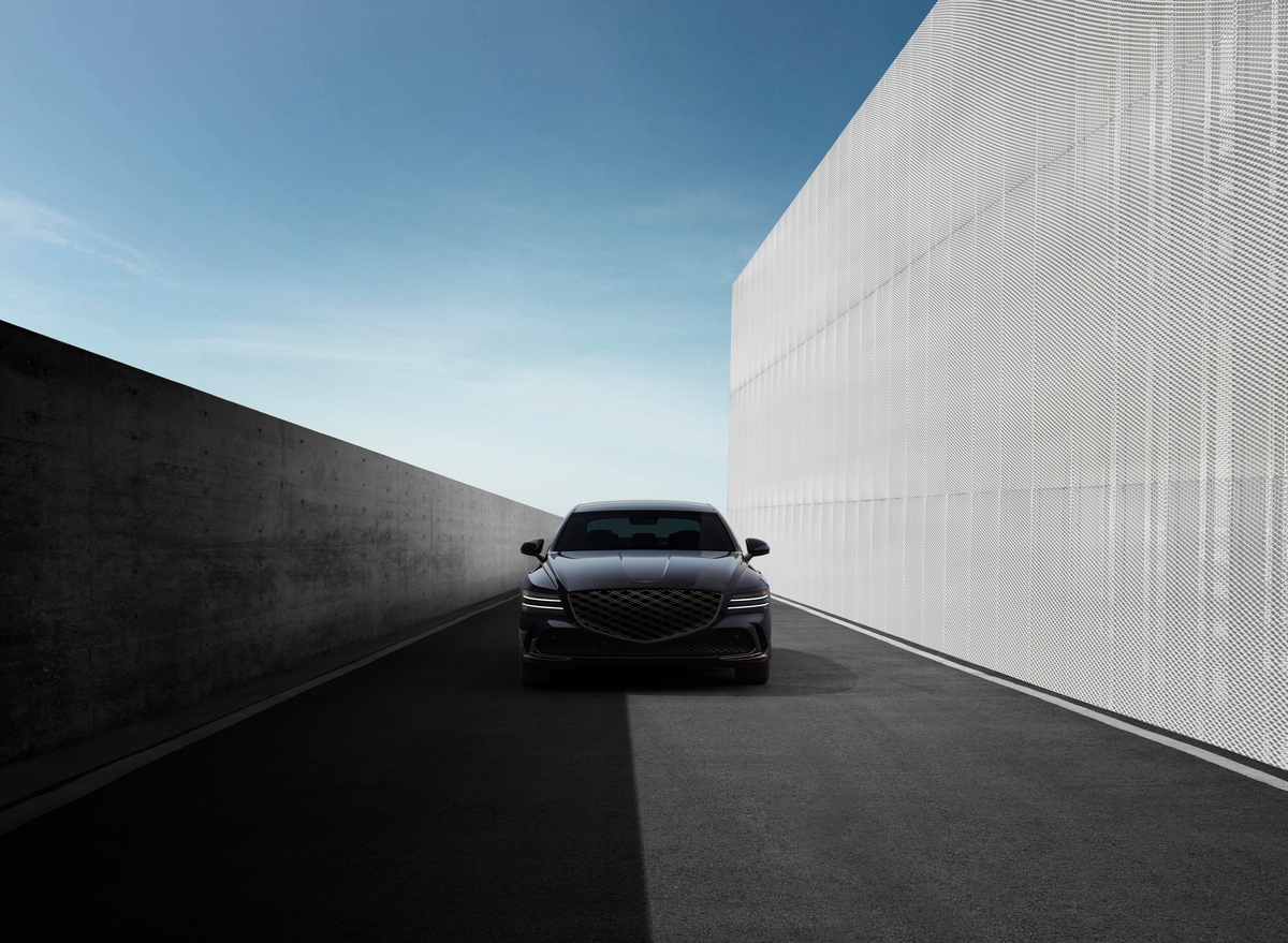 Front view of Genesis G80 Prestige Black parked between modern buildings