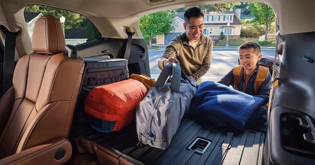 Family loading camping gear into the cargo area of a Subaru Ascent with the rear seats folded