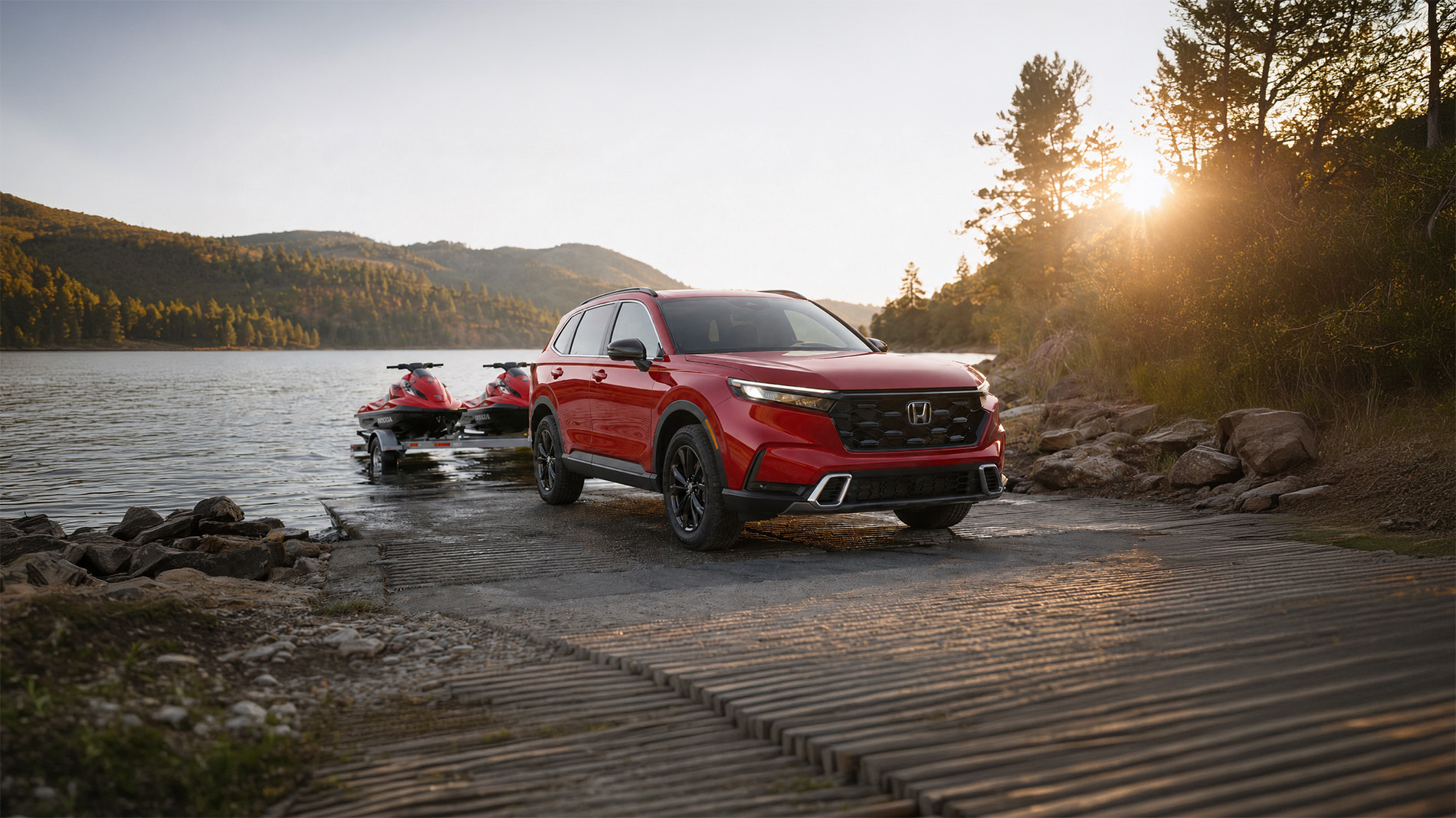 2026 Honda CR-V towing two small personal watercraft and backing them toward a lake