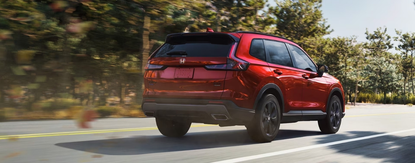 Red 2026 Honda CR-V Hybrid Sport Touring driving on a highway