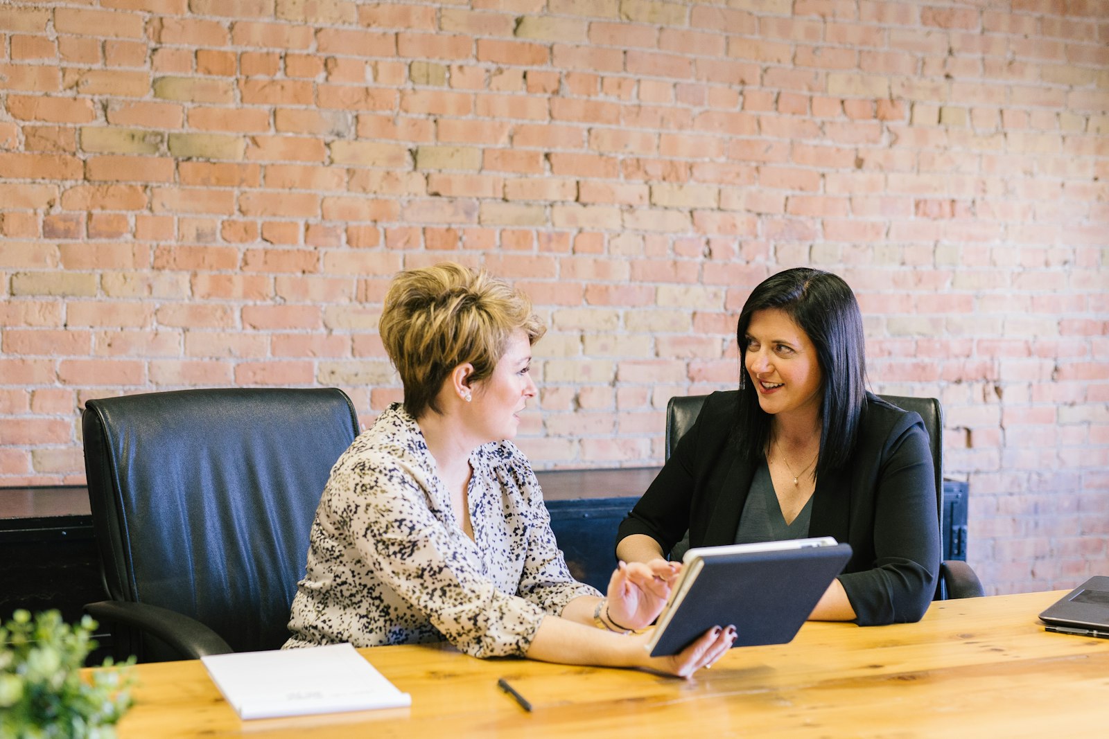 Customers reviewing paperwork with a dealership sales consultant