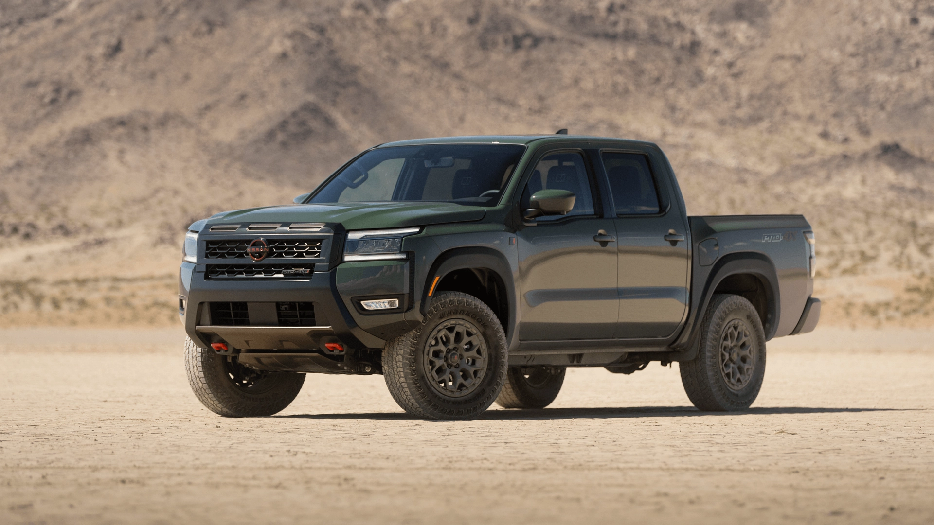2026 Nissan Frontier® PRO-4X pickup parked on desert terrain with rugged tires and mountain backdrop