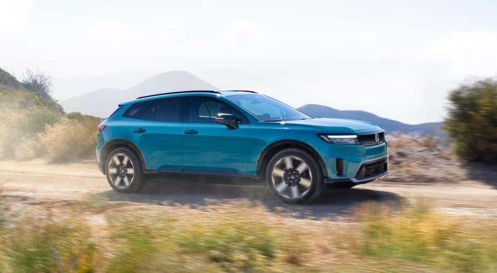 A blue 2024 Honda Prologue is shown from the side on a dirt trail after leaving a dealer that has a Honda Prologue for sale.