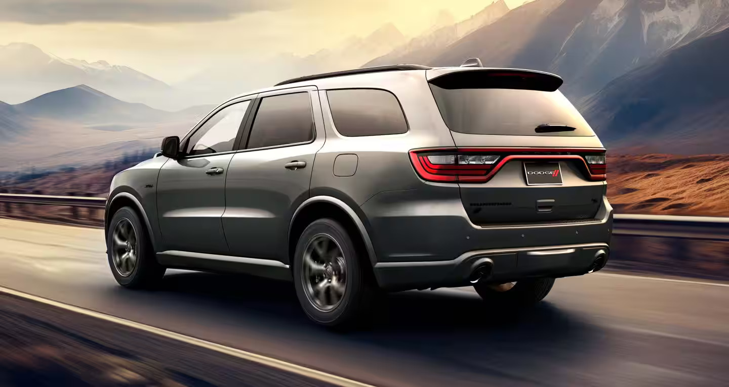 A silver suv driving on the road.