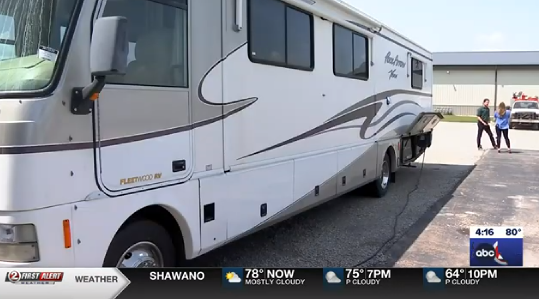 News Report of RV with News Anchors in background