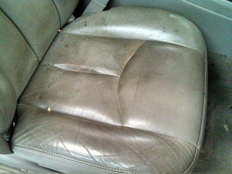 Dirty, worn leather car seat before cleaning