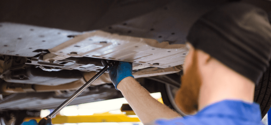Technician working under a car on a lift