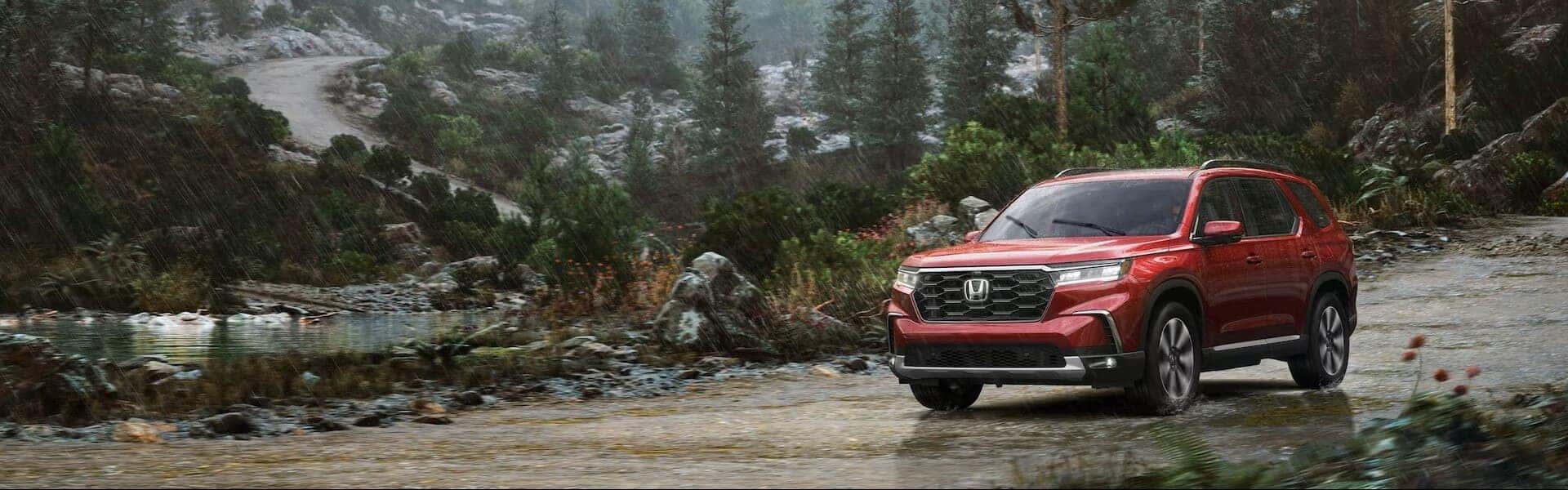 2024 Honda Pilot Elite Driving Past The Forest