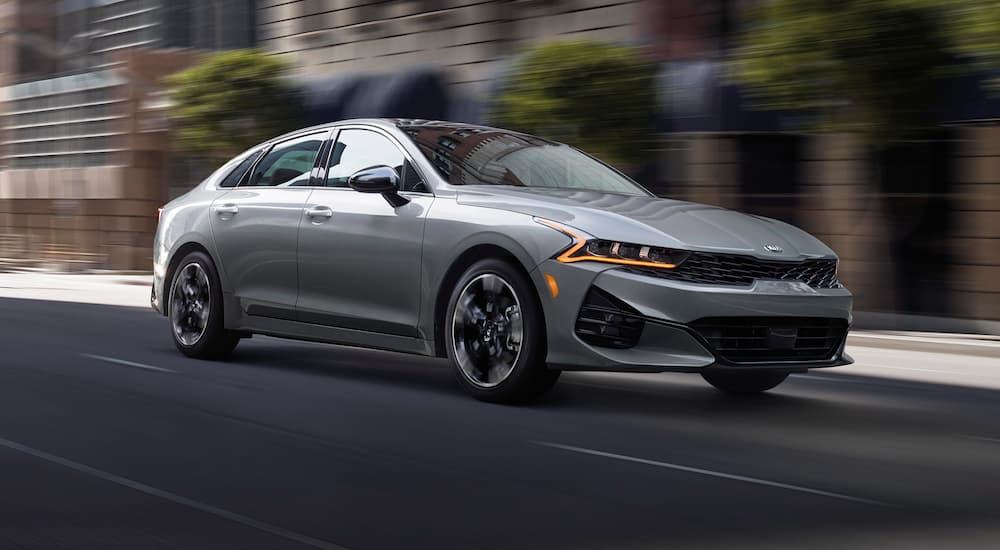 Grey 2021 Kia K5 driving on a city street