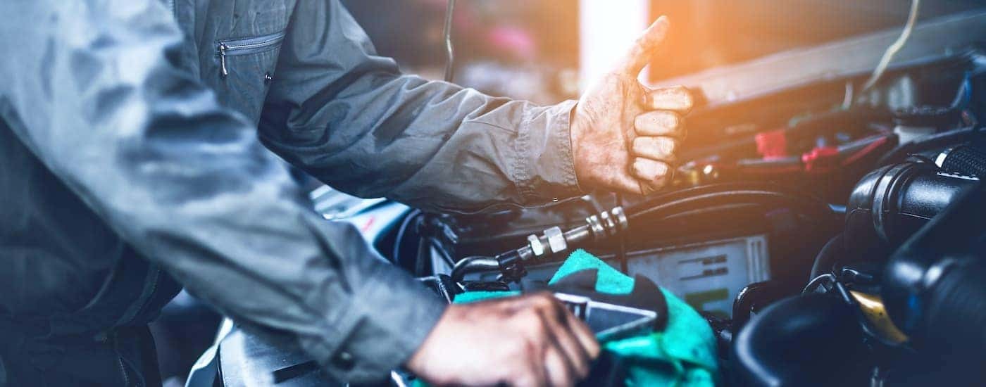 A mechanic is shown giving a thumbs up during a Honda car repair.