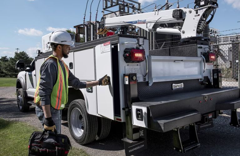 Worker in Hardhat and Vest Working with Ford Super Duty with Diesel Power Take Off