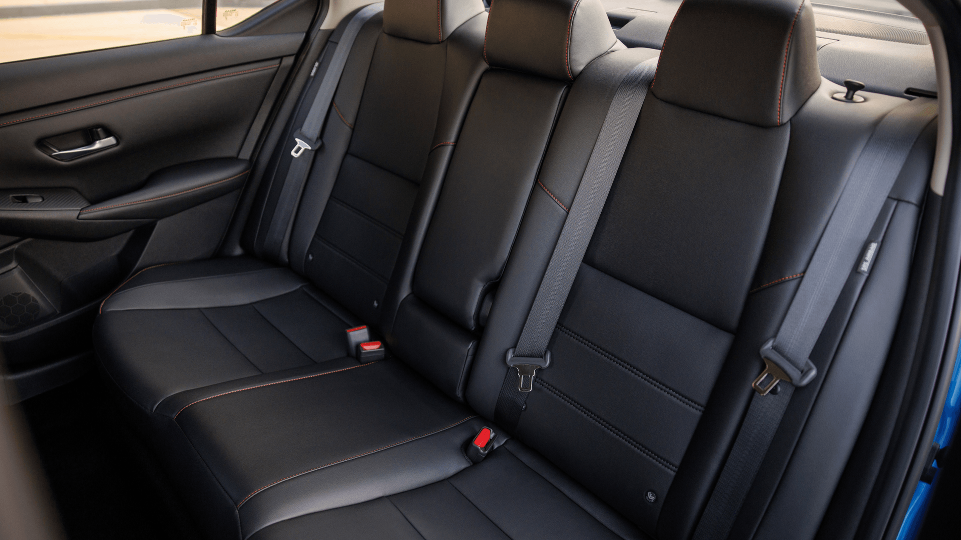 2025 Nissan Sentra® rear cabin showing black seats with contrast stitching, headrests, and seat belts.