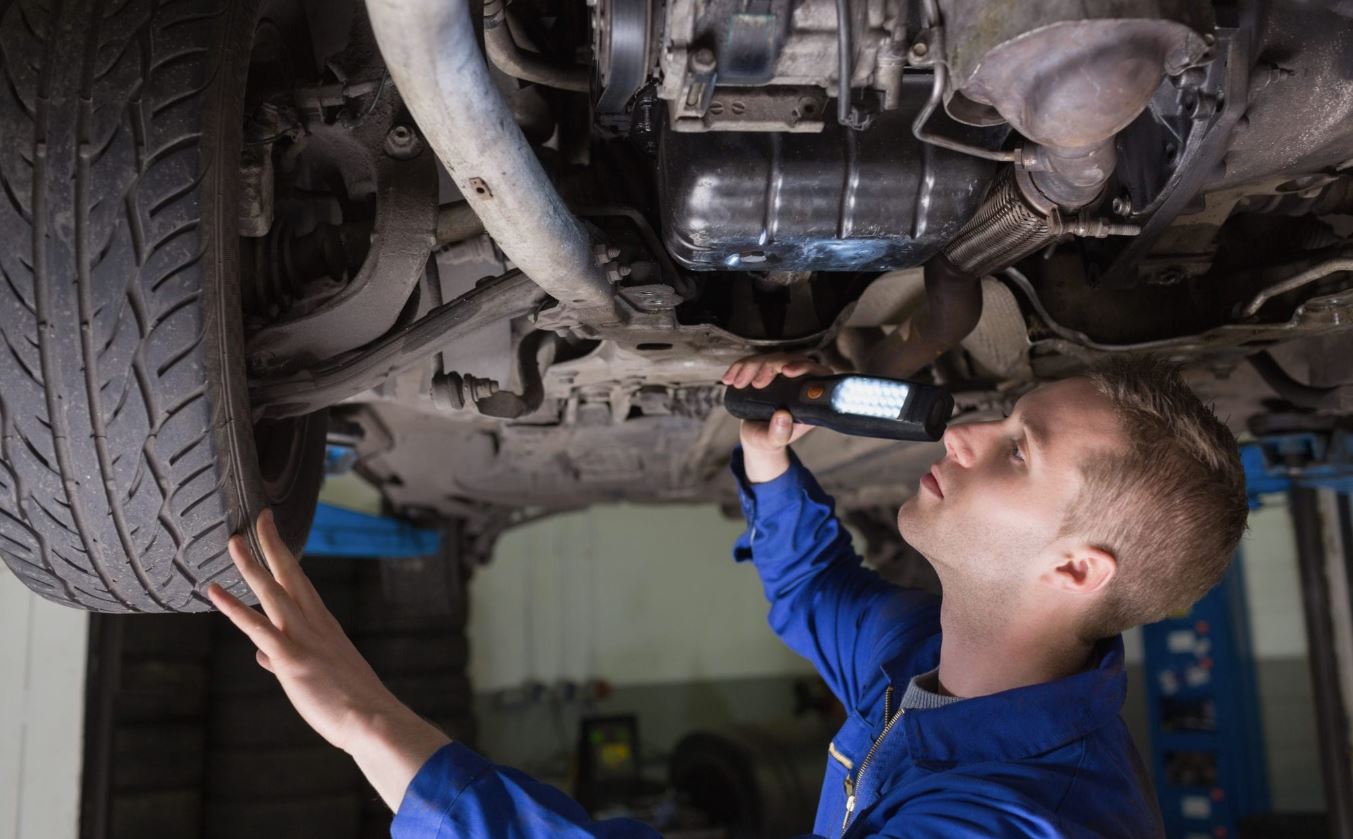 expert technician checks the undercarriage of a mobility van