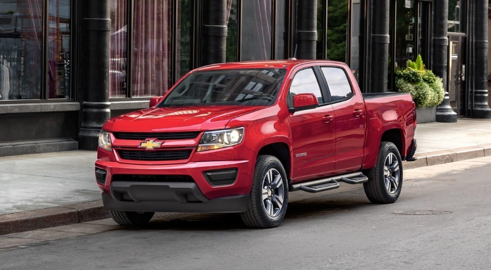 A red 2020 Chevy Colorado is shown parked on a city street.