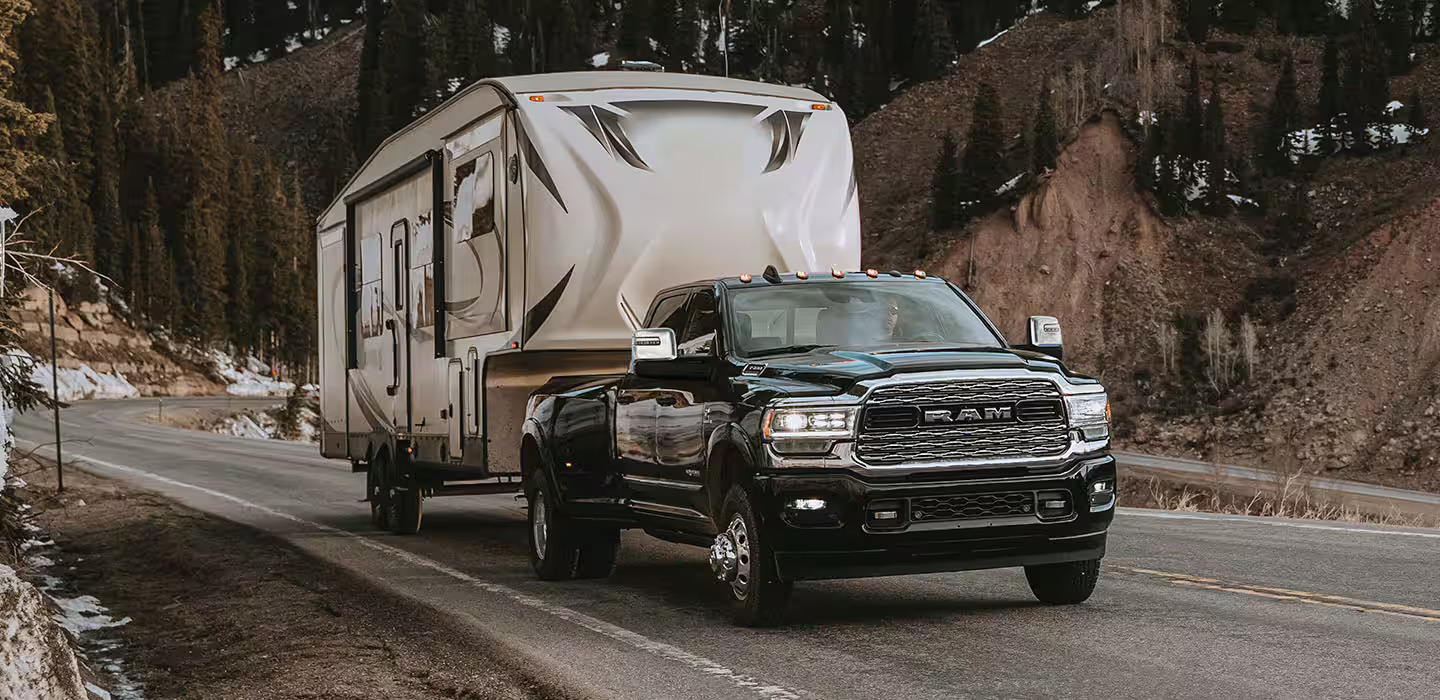 Black Ram 3500 pulling a mobile home.