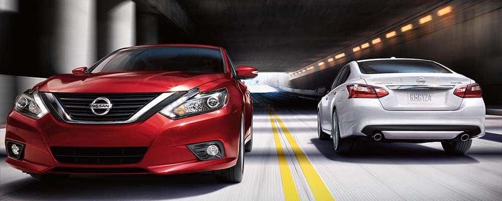 Red and white Nissan Altima sedans driving through a tunnel