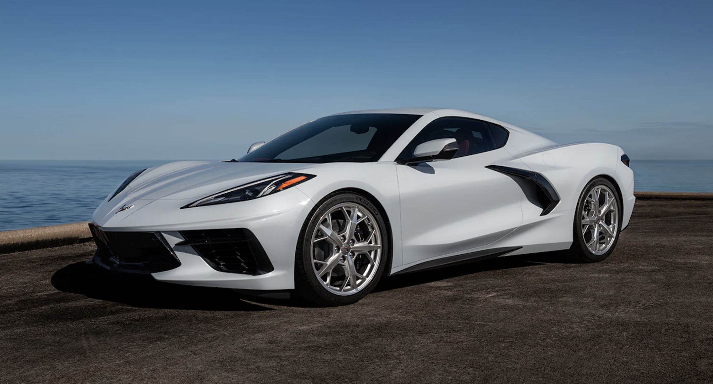 A white 2022 Chevrolet Corvette parked on the road by the water
