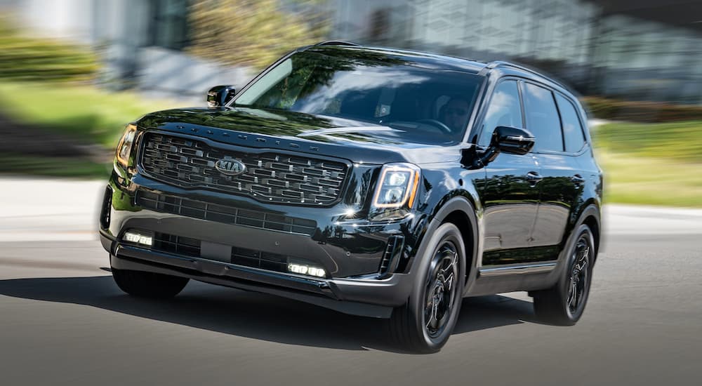 Black 2021 Kia Telluride driving to a used Kia dealer