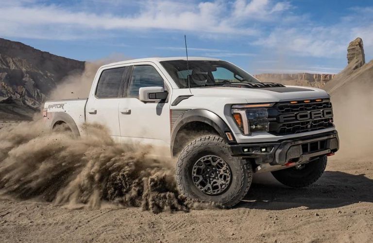White 2025 Ford F-150 Raptor Kicking Up Dirt on the Trail