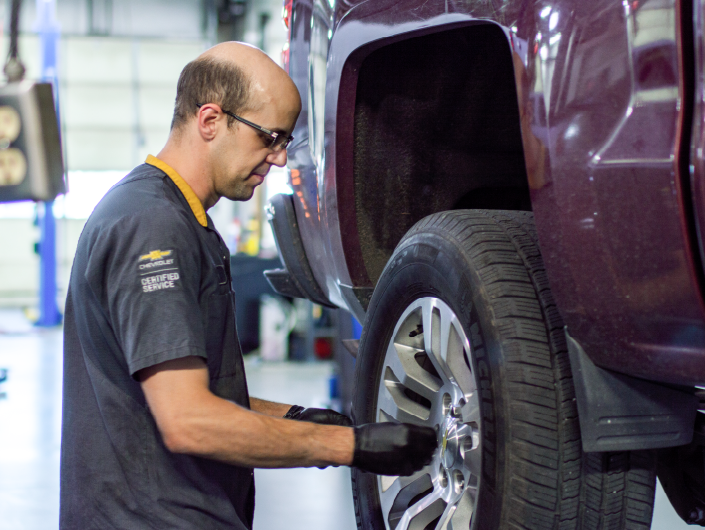 Don Hattan Chevrolet technician rotating tires on a truck