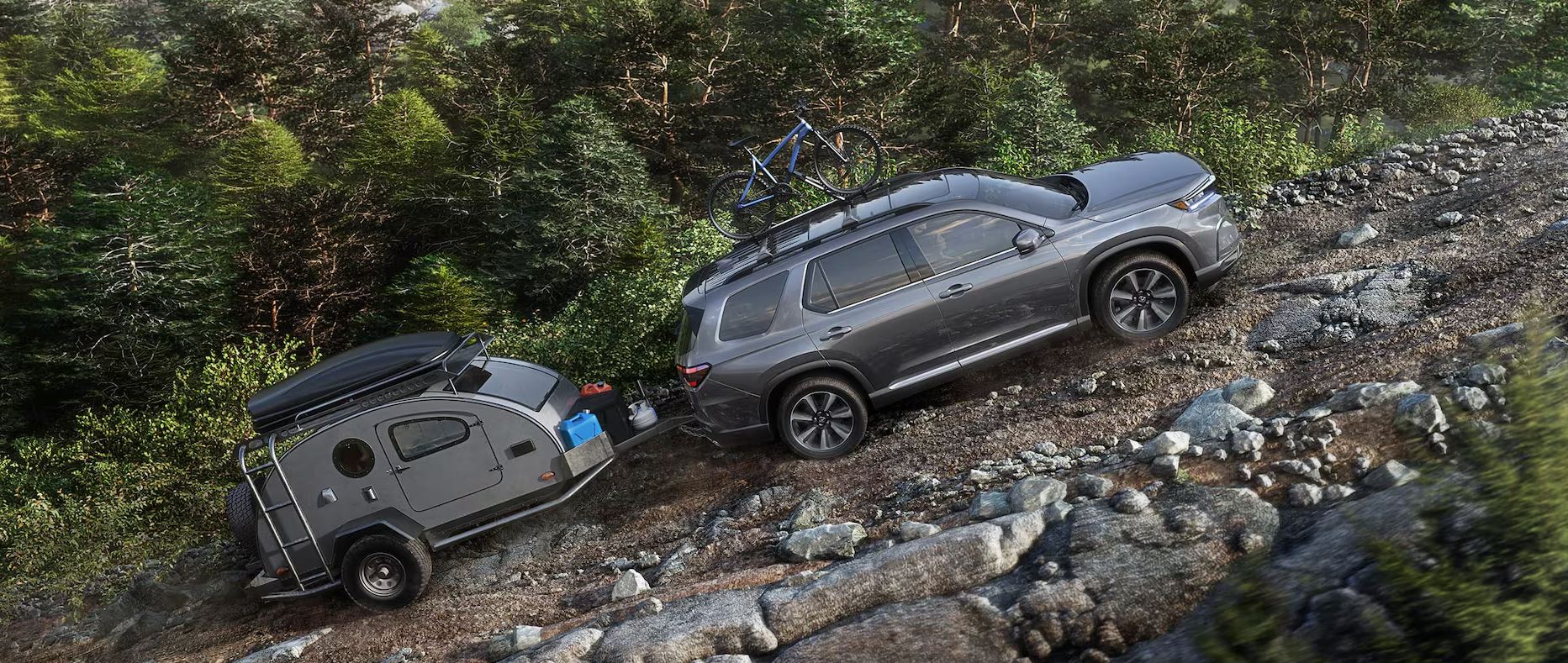 gray 2025 Honda Pilot tows a mini-lite camper up a rocky trail