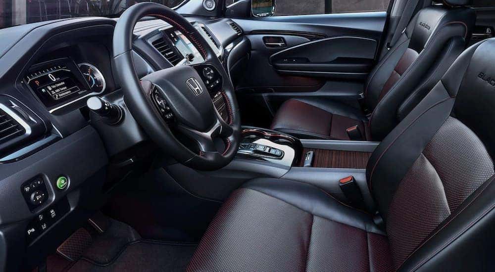 The interior of a 2021 Honda Pilot shows the steering wheel and infotainment screen.