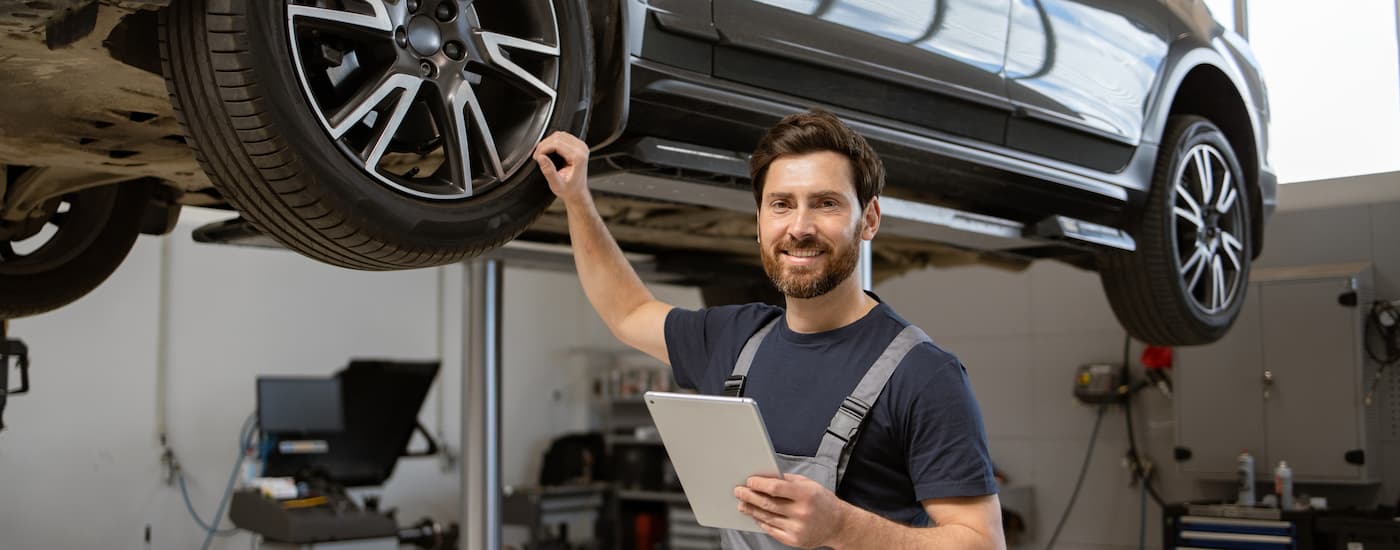 A mechanic is shown standing in a auto body shop in Rochester, NY