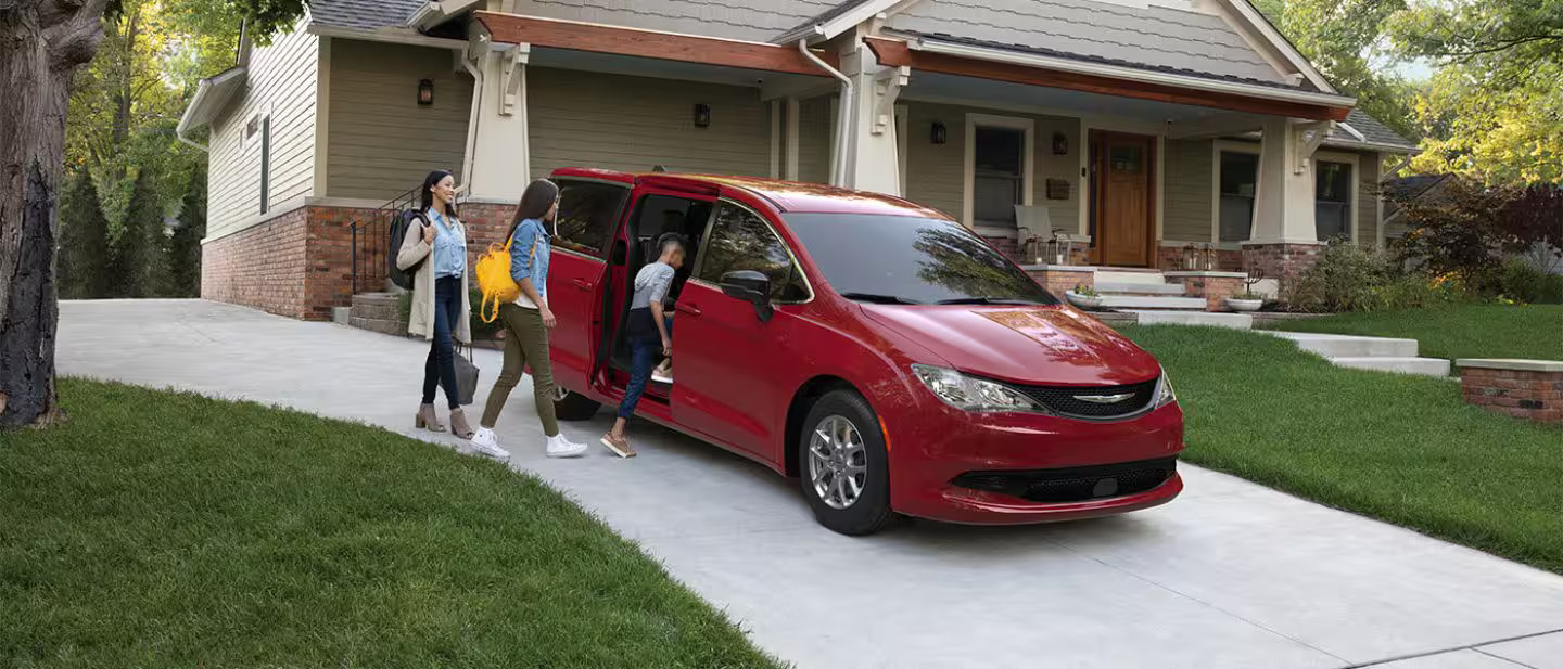 A family getting into a red van.