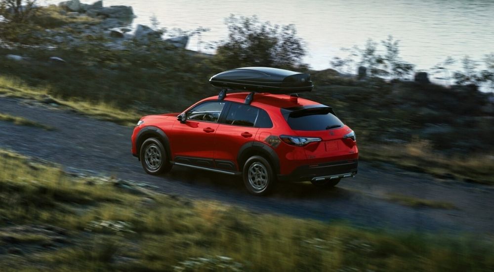 Red 2026 Honda HR-V Sport HPD driving past a lake
