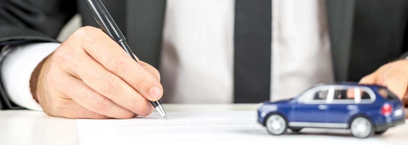 Car paperwork with tiny blue car
