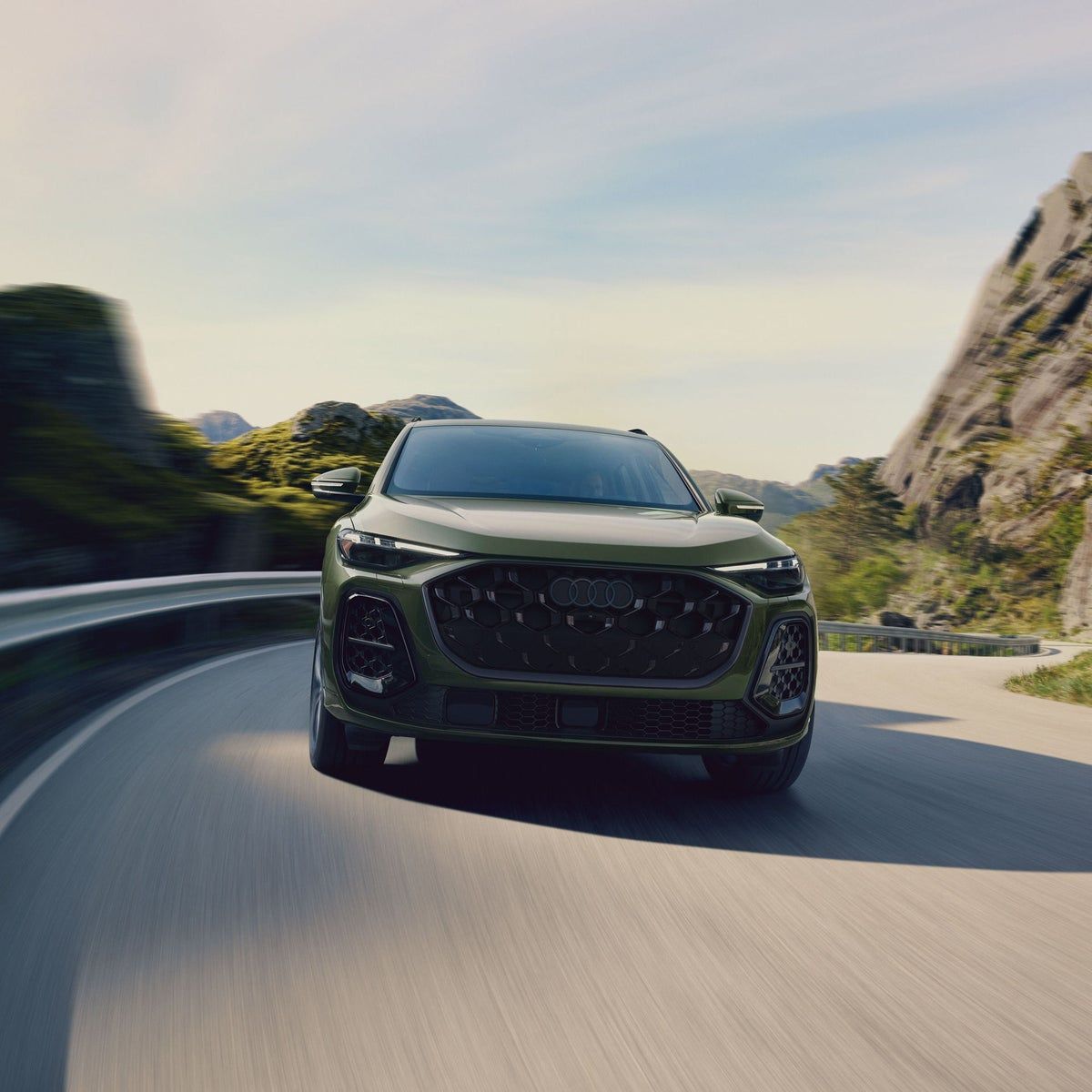 Front view of the redesigned 2026 Audi Q5 driving on a Queens parkway