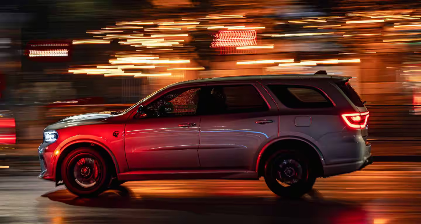 A silver suv driving on the road.