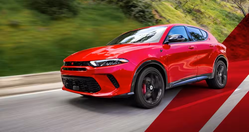 a red car driving on a paved road