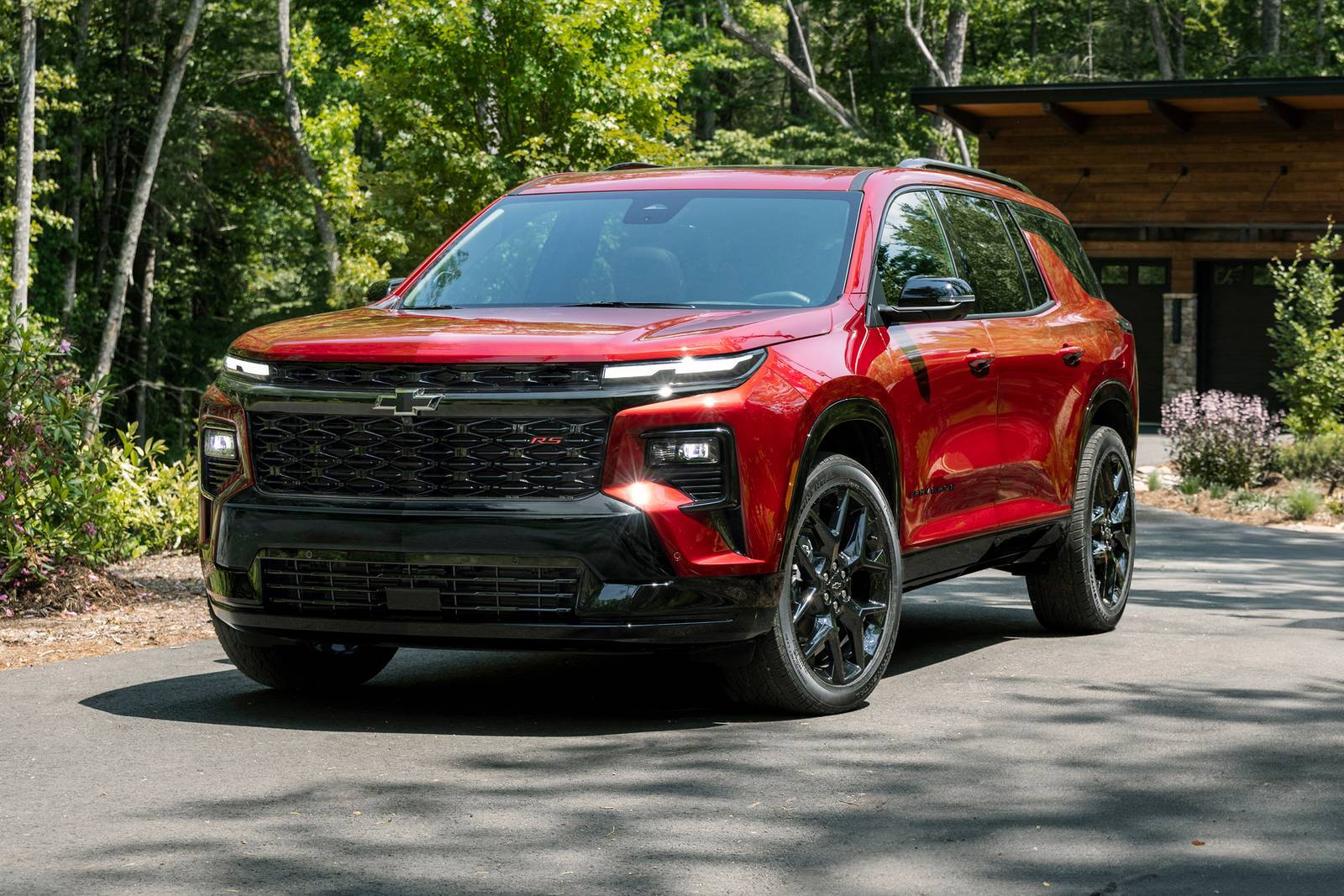 A red suv sitting parked in a driveway.