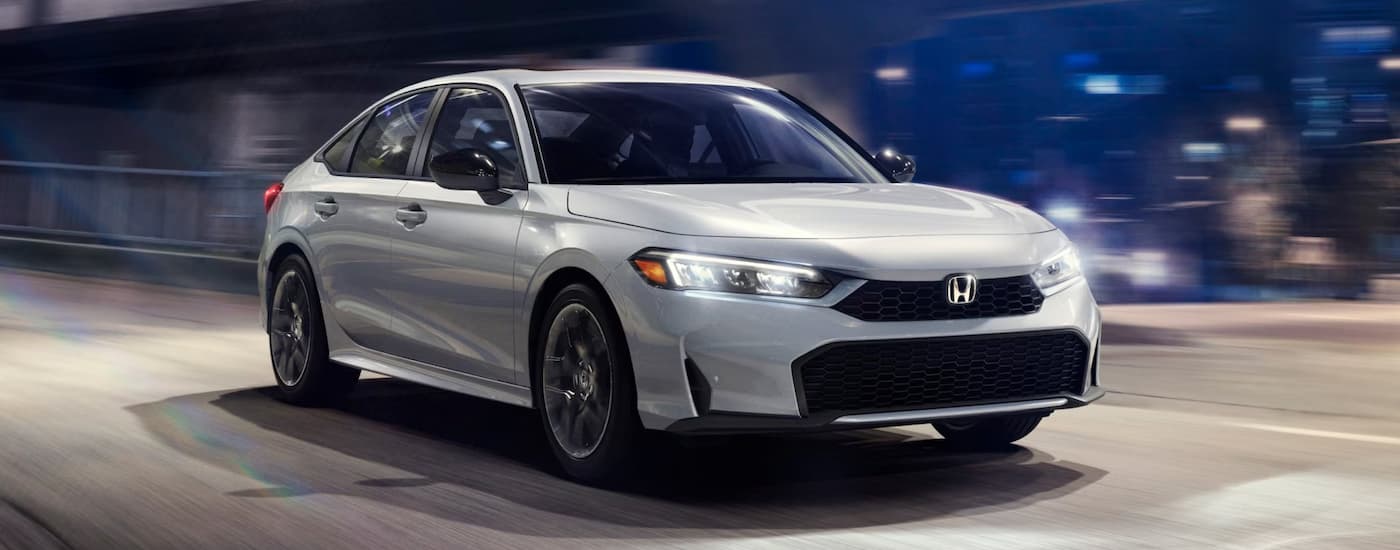 White 2024 Honda Civic driving on a highway at night