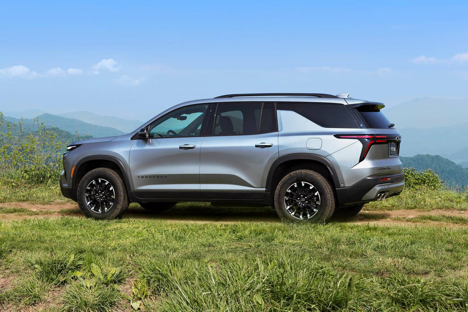 A gray suv sitting parked in the grass.