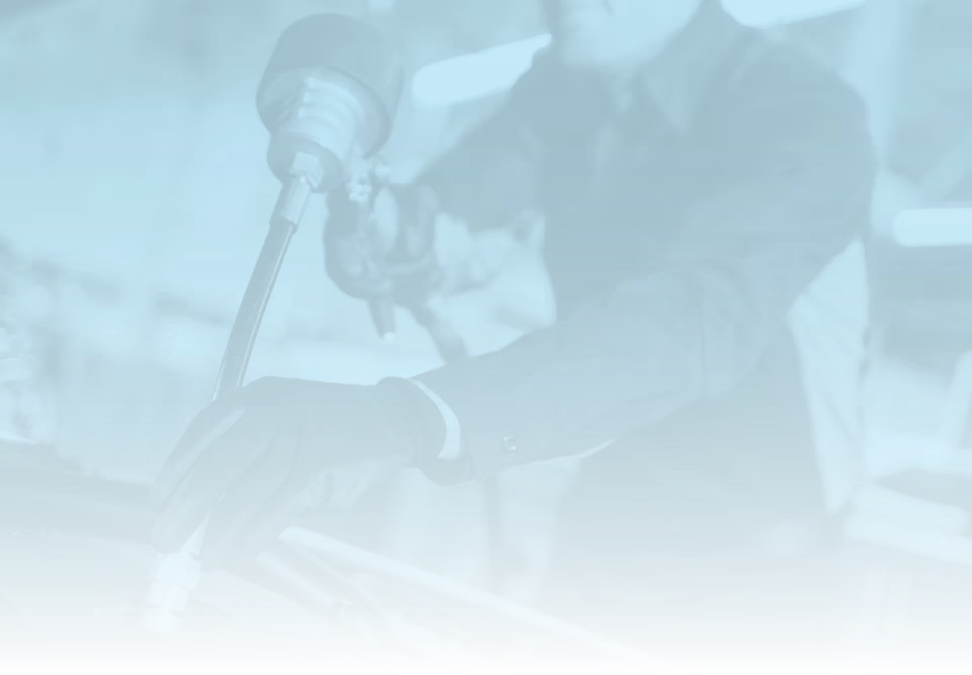 Light blue and black image of vehicle service technician filling fluids under the hood of vehicle.