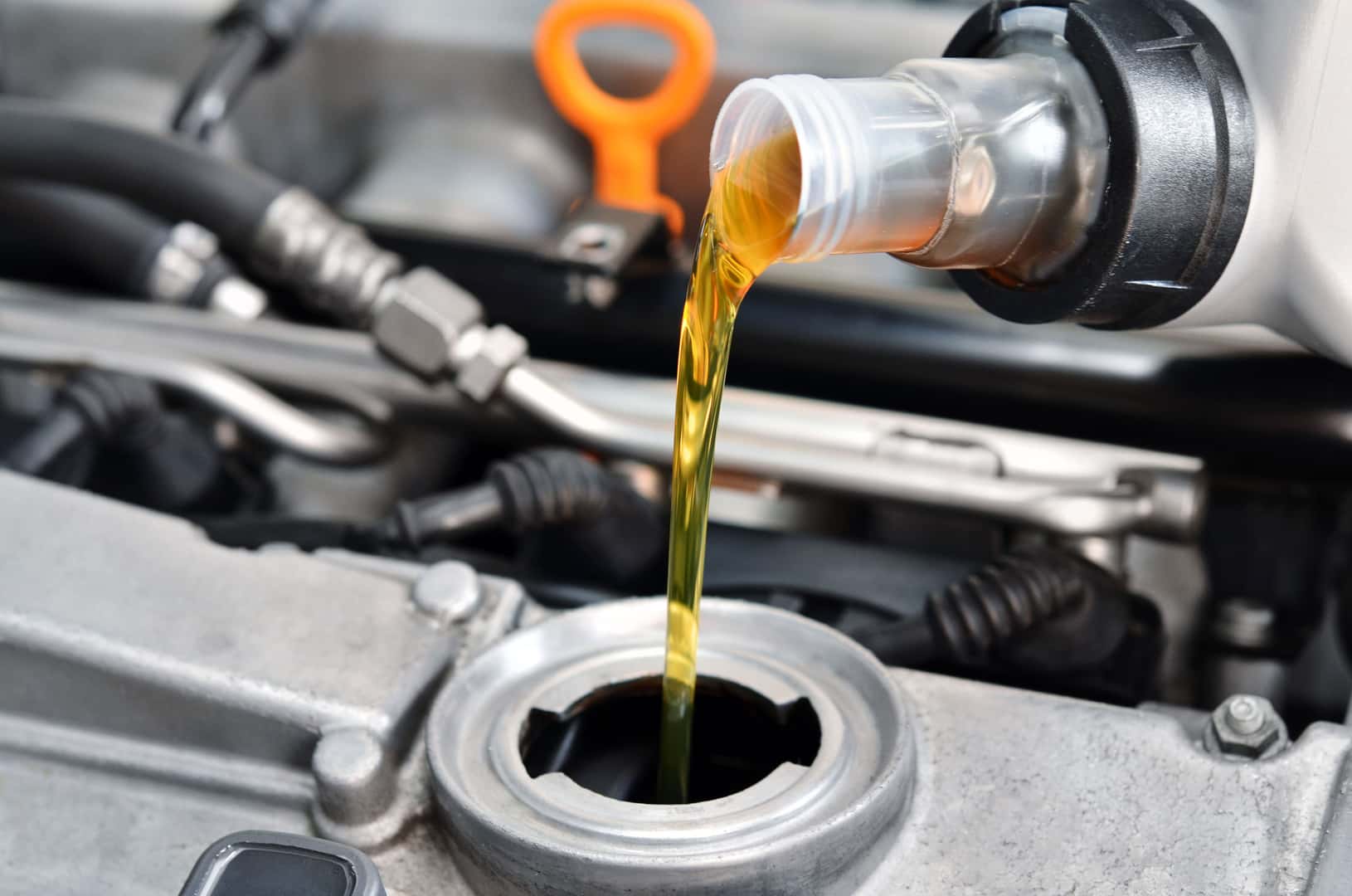 Fresh motor oil being poured into a Nissan engine
