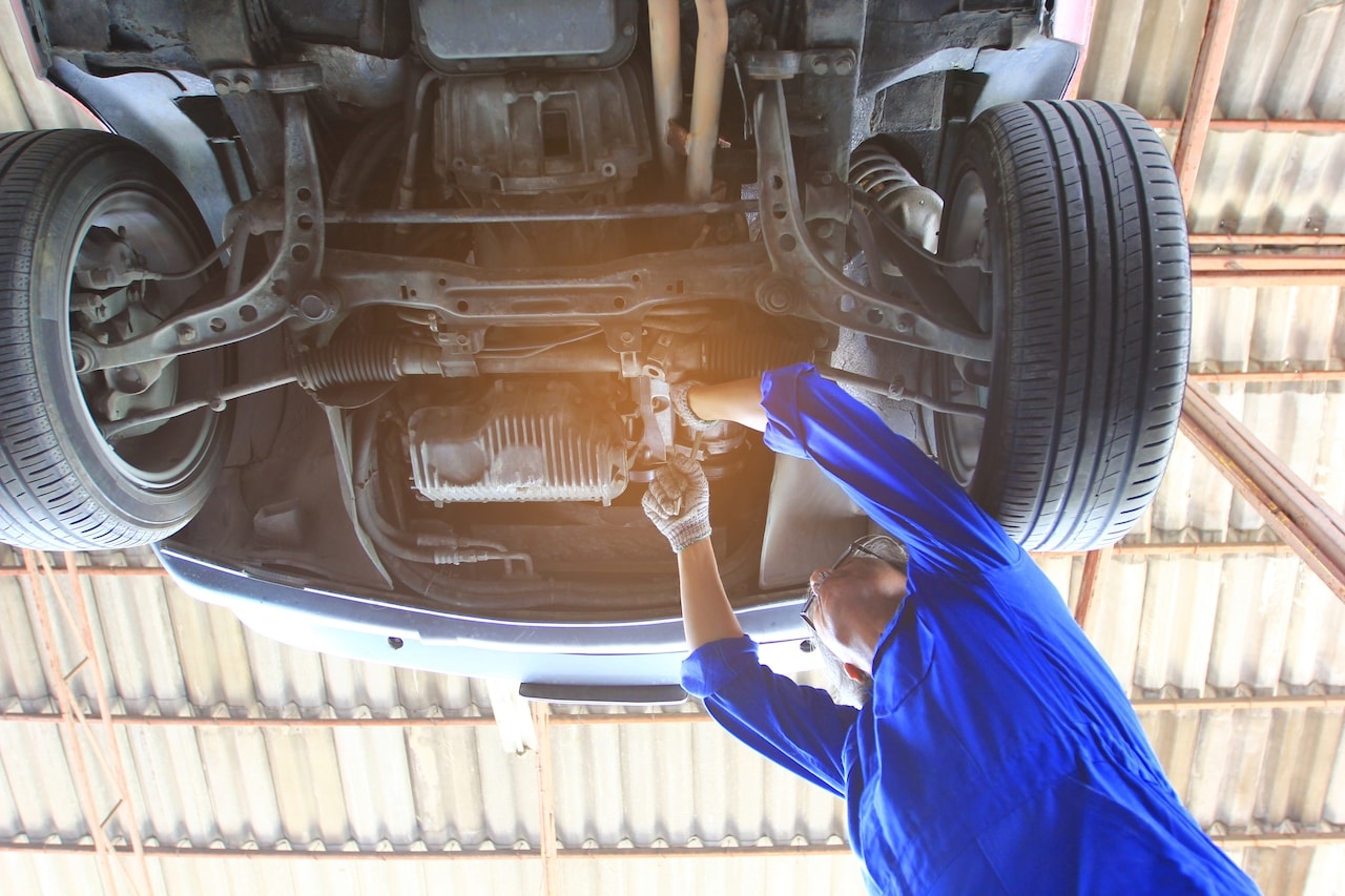 Honda technician servicing a vehicle on a lift at Allen Honda in College Station, TX