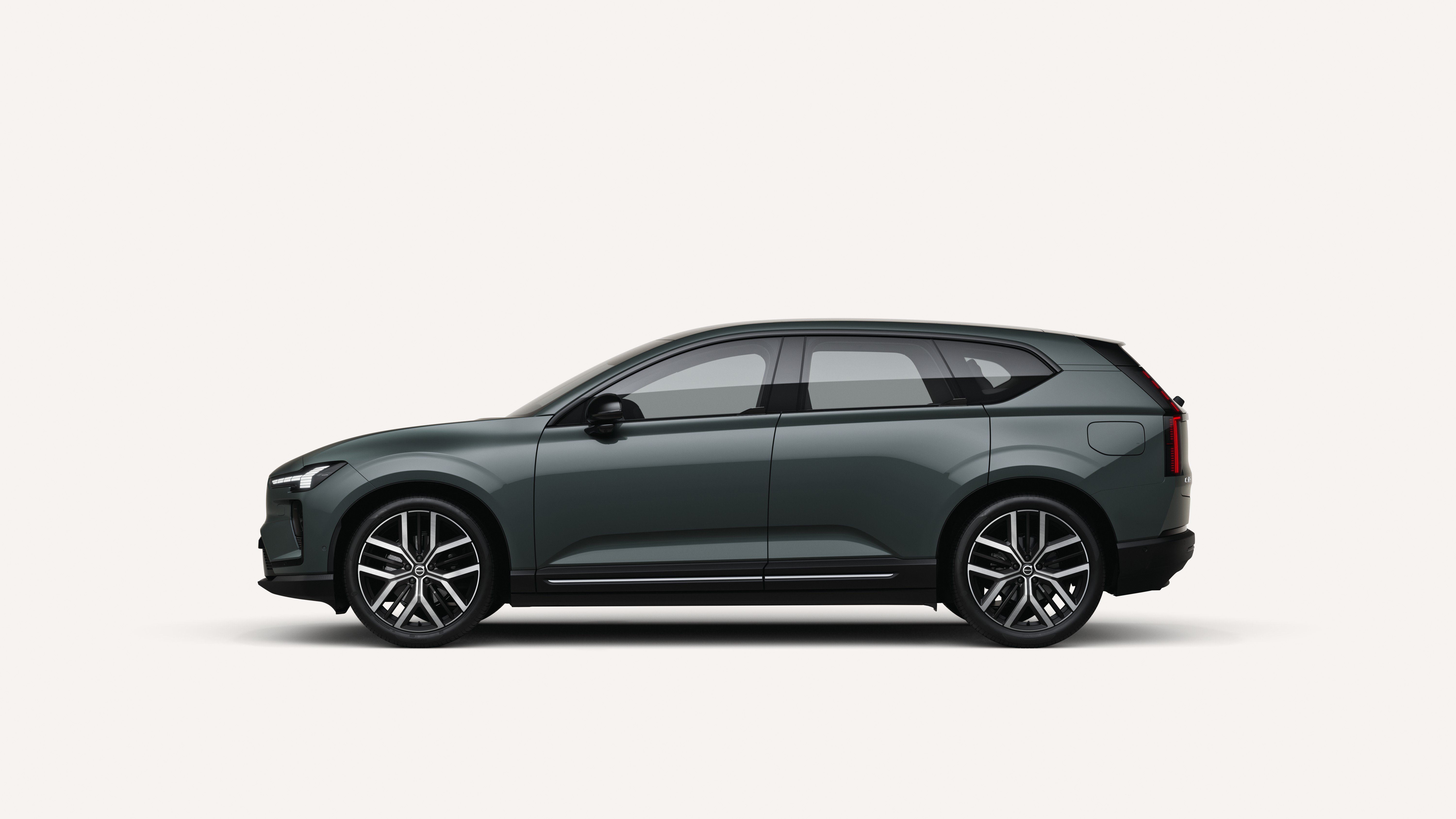 Gray-green 2027 Volvo EX60 electric SUV shown in side profile against a plain studio background at Kunes Mercedes-Benz of Sycamore.