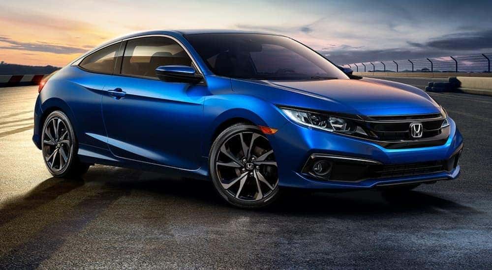 A blue 2020 Honda Civic coupe is shown from the front at an angle after leaving a Certified pre-owned car dealer