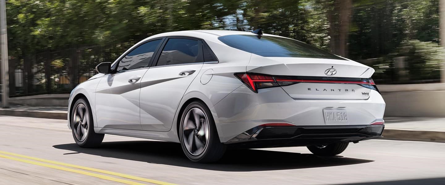 A white 2022 Hyundai Elantra Hybrid driving down the road. 